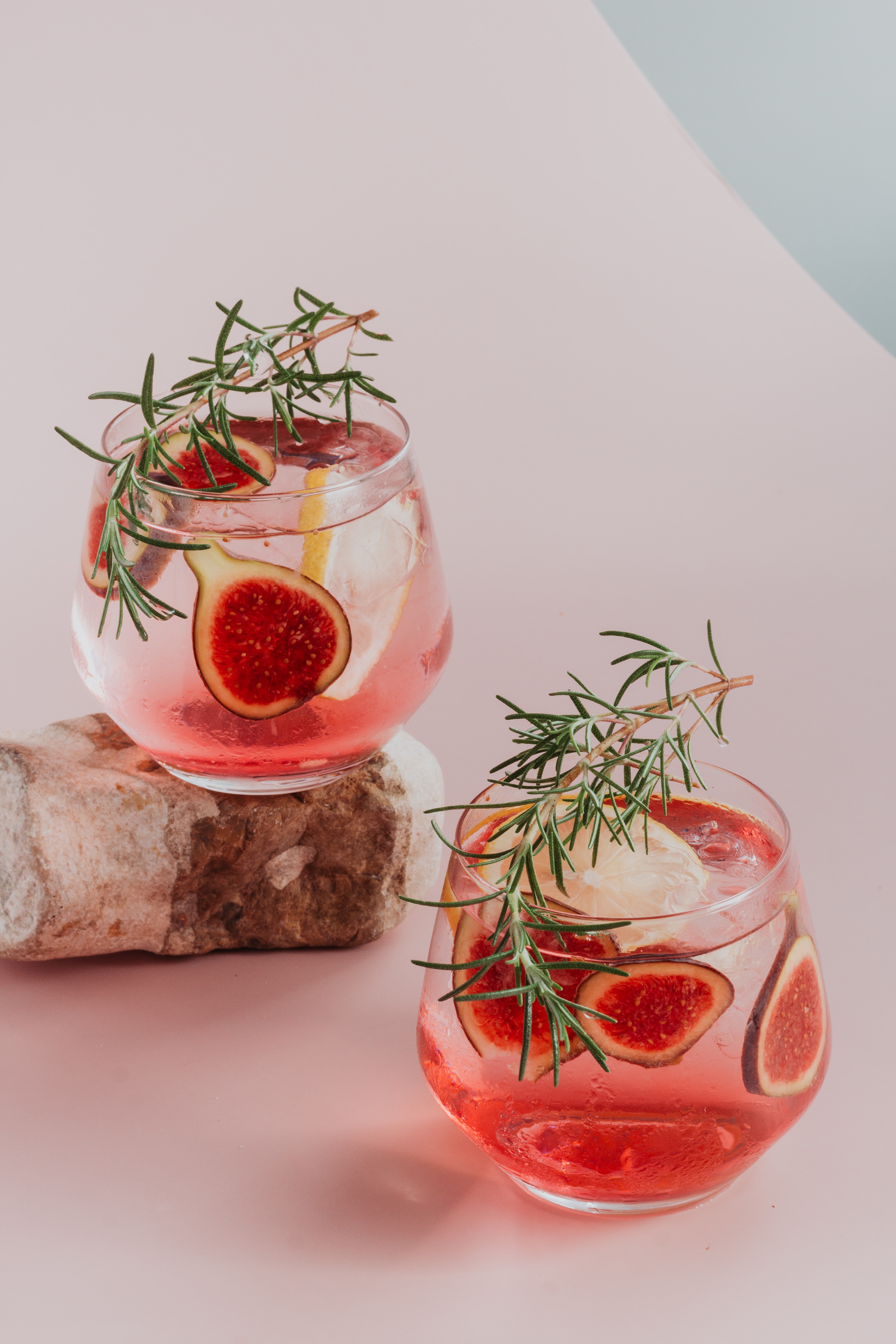 Two lemon fig cocktails with a rosemary garnish.