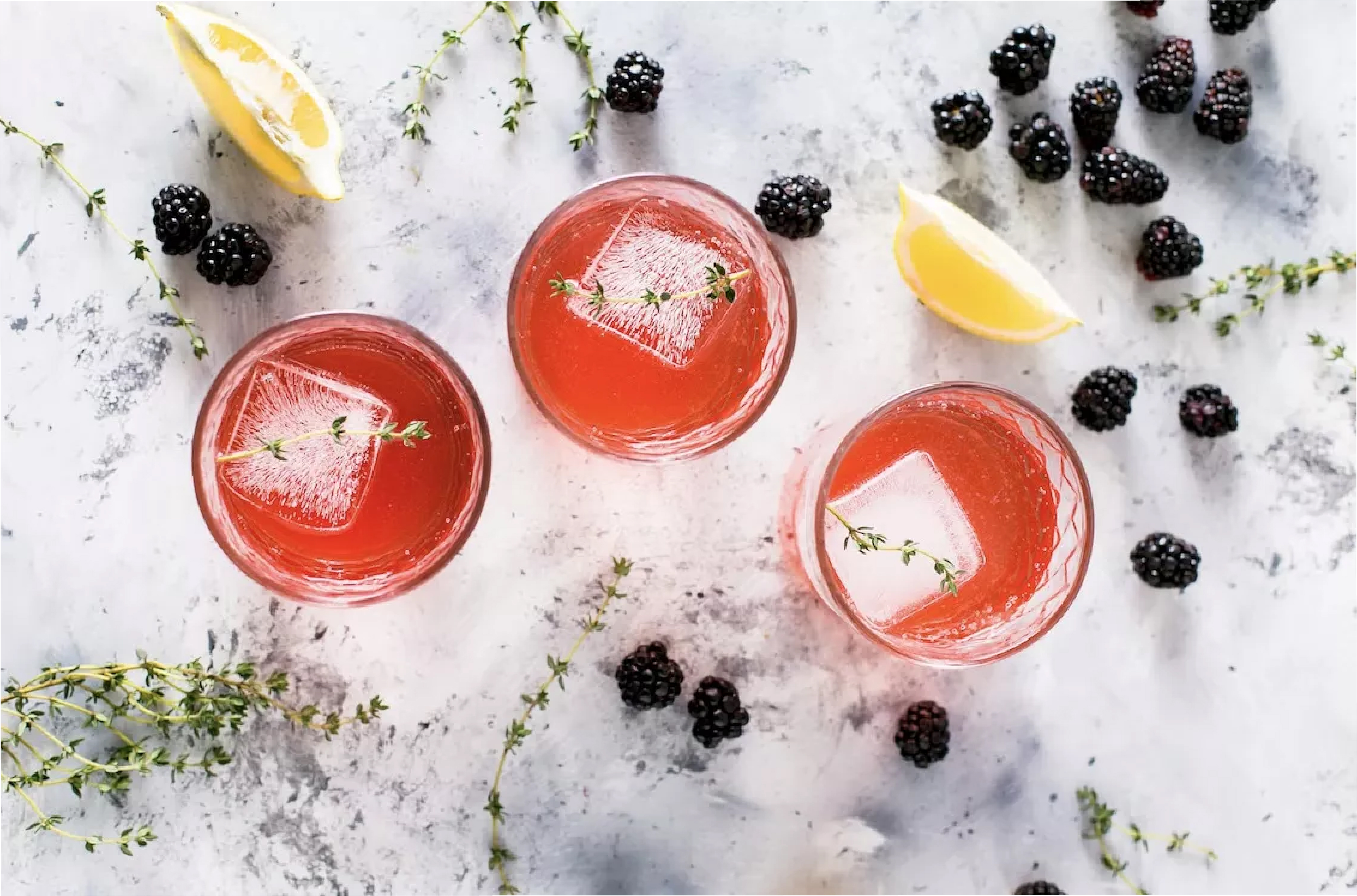 Top view of 3 cocktails on a marble countertop.